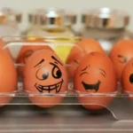 Eggs in a fridge showing verious different emotions in their painted faces.
