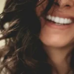 A smiling womans chin and mouth area
