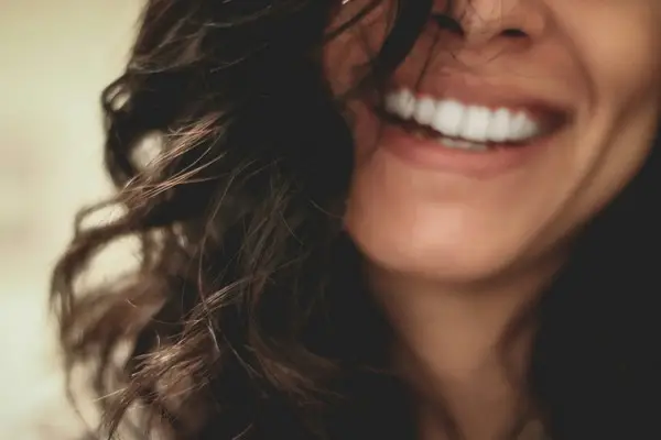A smiling womans chin and mouth area