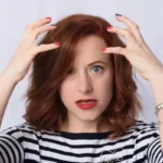 A woman looking stressed with her hands in the air