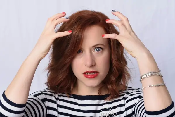 A woman looking stressed with her hands in the air