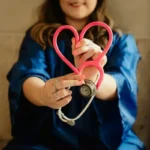 A medical and health social worker holding a stethoscope in the shape of a heart