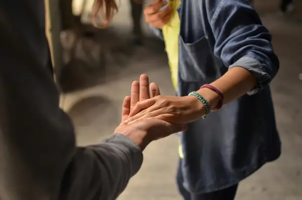 A social worker holding hands with a service user