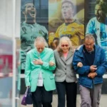 three older people sitting at a bus stop