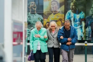 three older people sitting at a bus stop