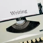 A typewriter with a paper saying 'writing'