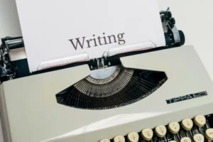 A typewriter with a paper saying 'writing'