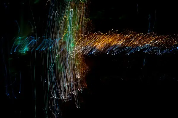 An abstract squiggley image of many colours against a black backgorund