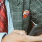 A man in a suit holding a phone