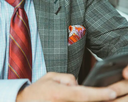 A man in a suit holding a phone