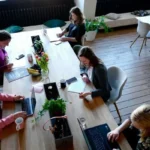 A group of middle class professionals working at a table with laptops