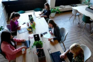 A group of middle class professionals working at a table with laptops