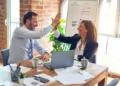 a male and female employee sat at a table doing a high five