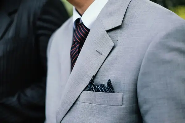 A man in a grey suit and white collared shirt