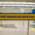 An airport barrier with the words 'China Imiigration Inspection".