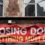 A sign on a building stating 'closing down sale - everything must go'