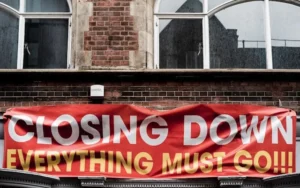 A sign on a building stating 'closing down sale - everything must go'