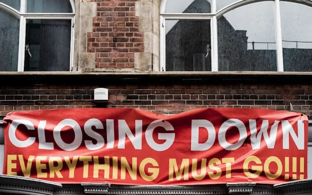 A sign on a building stating 'closing down sale - everything must go'
