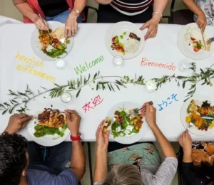 Plates on a white table with welcome words from various languages