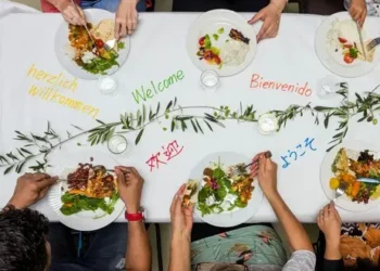 Plates on a white table with welcome words from various languages