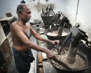 A shirtless man grinding stones