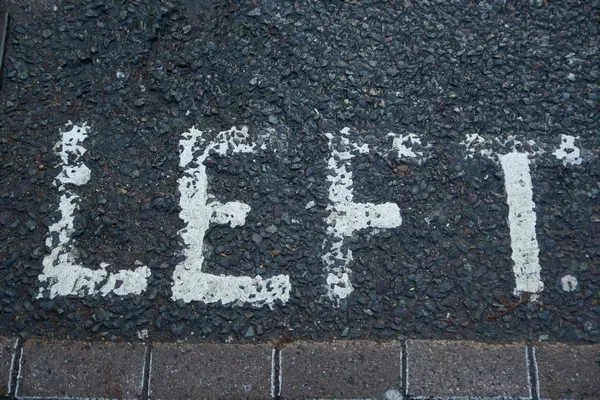 A road marking which says the word left