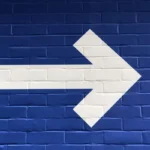 A white arrow pointing right against a blue background