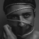 A man with rope around his head feeling the strain