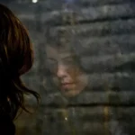 A woman's reflection in a window during an identity crisis