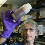 A man holding up a science experiment