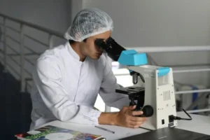A scientist looking into a microscope.