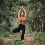 A woman performing a yoga stance in the forest