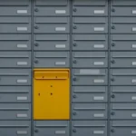 A grey set of drawer units with a single yellow draw.