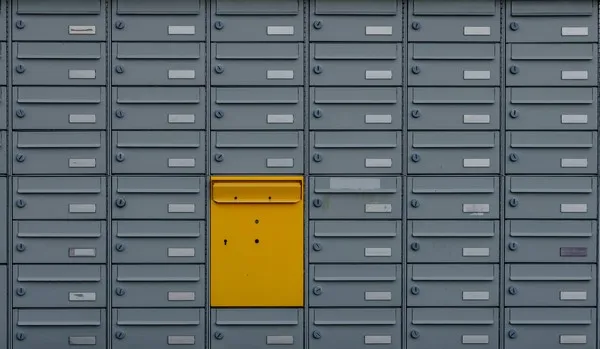 A grey set of drawer units with a single yellow draw.